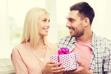 happy man giving woman gift box at home