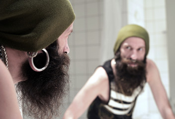 Mann mit Bart schaut in einen Spiegel