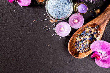 spa massage setting, lavender product, oil on black stone background