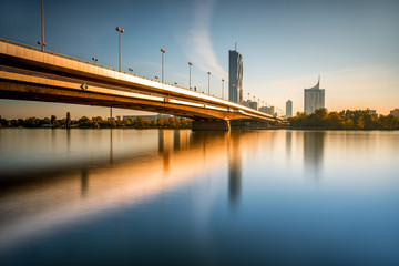 Fototapeta na wymiar View on Donaucity with bridge in Vienna in the morning. Wide angle image with long exposure technic with glossy water and reflection