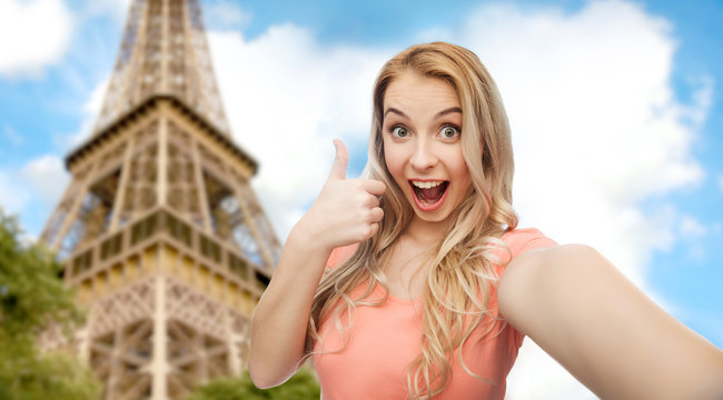 happy woman taking selfie and showing thumbs up