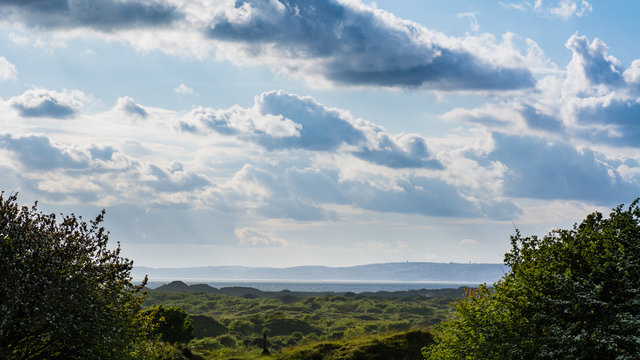 Dunes of Kenfig National Nature Reserve in Wales, UK. Landscape of sand dunes under a cloudy sky on the Welsh south coast