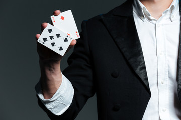 Closeup of man magician holding two playing cards