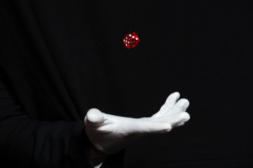 Hand of magician in white glove showing tricks with dice