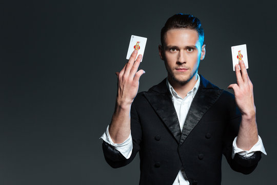 Attractive young man magician showing two jocker cards