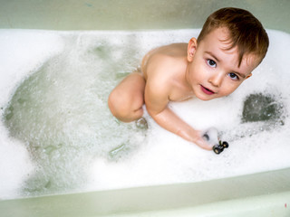 Little boy plays in a bubble bath