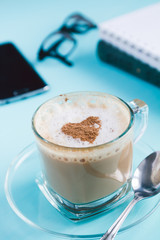 Cappuccino, note books and phone  on a blue table