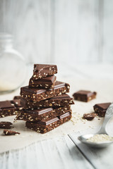 chocolate stack, chips and seeds of sesame on a wooden table