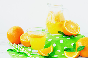 
detox , healthy and refreshing drink, juice or lemonade, Nutritious cold sparkling water with fresh green mint and orange in the jar on a wooden background