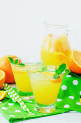 
detox , healthy and refreshing drink, juice or lemonade, Nutritious cold sparkling water with fresh green mint and orange in the jar on a wooden background