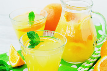 
detox , healthy and refreshing drink, juice or lemonade, Nutritious cold sparkling water with fresh green mint and orange in the jar on a wooden background