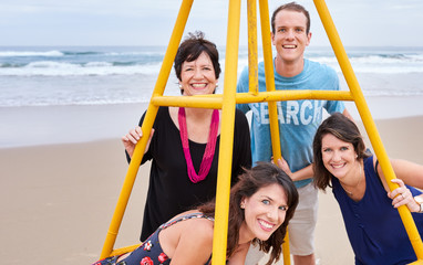 Family posing together around a structure on the beach