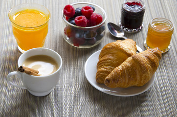 Close up of black coffee with cinnamon stick and croissant