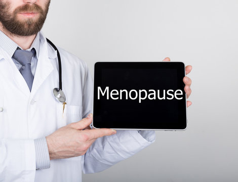 technology, internet and networking in medicine concept - Doctor holding a tablet pc with menopause sign. Internet technologies in medicine