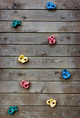 climbing wall of wooden planks with colored grips