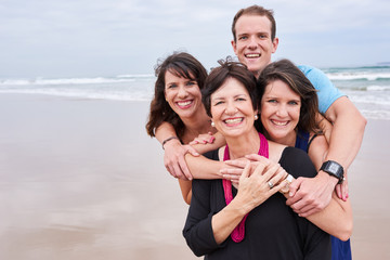 Happy healthy family hugging and smiling on the beach together