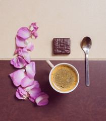 coffee mug with candy , petals and spoon