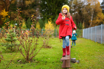 Cute little girl having fun on beautiful autumn day