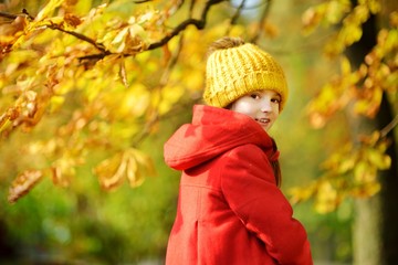 Cute little girl having fun on beautiful autumn day