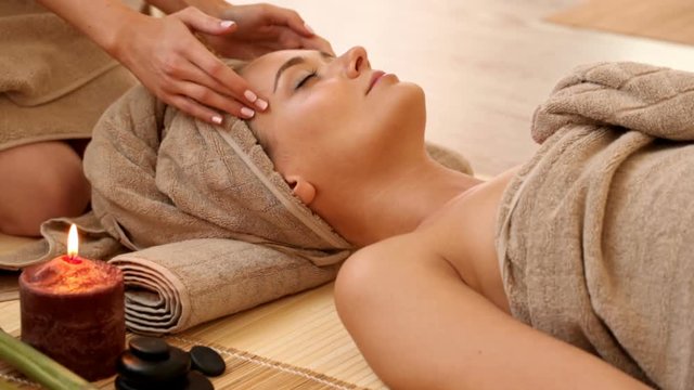 Woman getting facial massage in spa