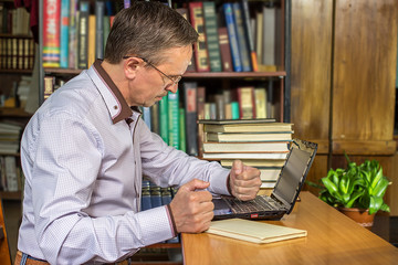 An angry businessman punches his computer after getting upset