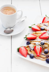 Pancakes with strawberries , blueberries and coffee