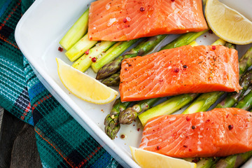 Fresh delicious salmon, green asparagus and lemon in pan