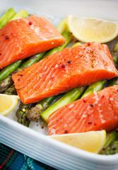 Fresh delicious salmon, green asparagus and lemon in pan