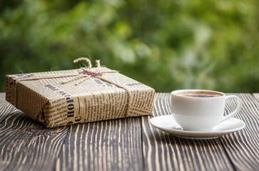tasse de café et une boîte sur une vieille table en bois
