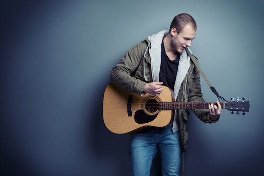 Handsome man is playing the guitar
