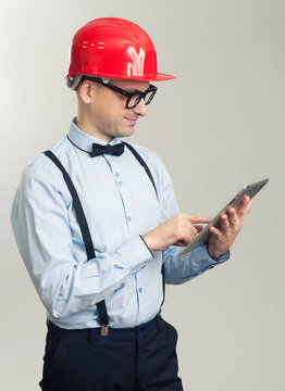 engineer wearing construction helmet and working on tablet