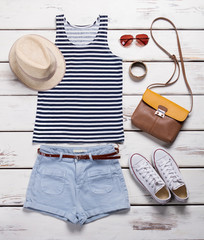 Light shorts with striped top. Girl's summer outfit on showcase.