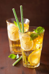 ice tea with lemon and mint on dark rustic background