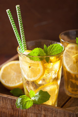 ice tea with lemon and mint on dark rustic background