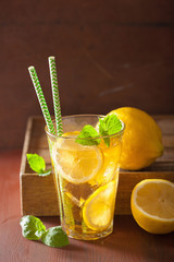 ice tea with lemon and mint on dark rustic background