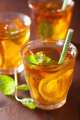 ice tea with lemon and mint on dark rustic background