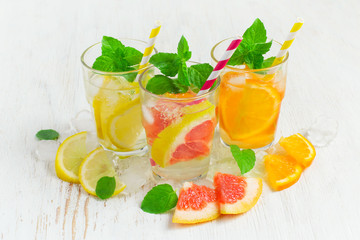 Refreshing summer drinks water with ice and lemon, orange  and