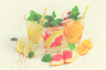 Refreshing summer drinks water with ice and lemon, orange  and