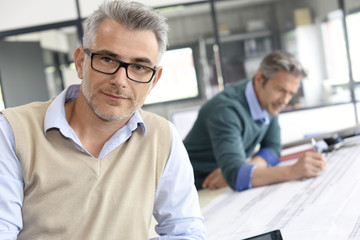 Portrait of mature engineer standing in office