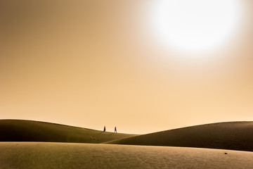 Couple marchant dans le désert avec coucher de soleil