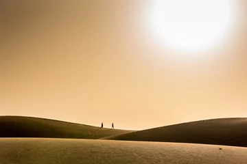 Zelfklevend Fotobehang Paar wandelen in de woestijn met zonsondergang © Simon Dannhauer