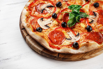 CLOSE-UP Tasty Italian Hot Pizza on dark wooden table with mushrooms, basil, tomato, olives and cheese. Look as Prosciutto, Capricciosa, Funghi, Cotto HOMEMADE PIZZA. Photo with space for text. 