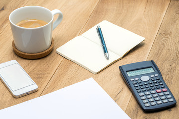 Wooden workspace with office supplies and coffee