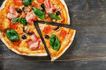 CLOSE-UP Tasty Italian Hot Pizza on dark wooden table with mushrooms, basil, tomato, olives and cheese. Look as Prosciutto, Capricciosa, Funghi, Cotto HOMEMADE PIZZA. Photo with space for text. 