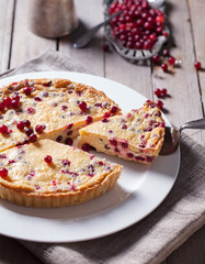 White chocolate cheesecake tart with cranberries on a white plate