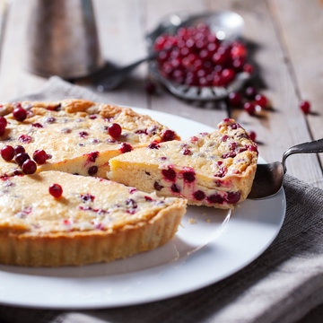 White chocolate cheesecake tart with cranberries on a white plate
