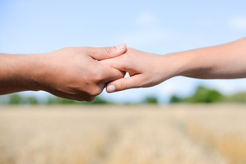 Handshake on outdoors blurred abstract nature background, image closeup 