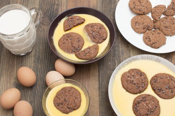 Flan de vainilla y galletas, natillas con galletas, jarra con leche, huevos frescos
