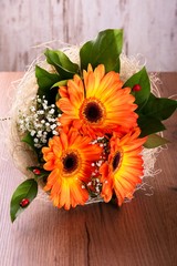 Bouquet of orange gerberas on wooden board