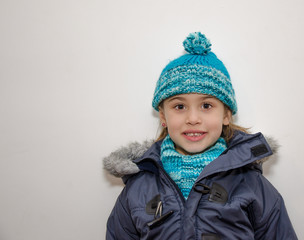 Niña rubia con ropa de abrigo en invierno